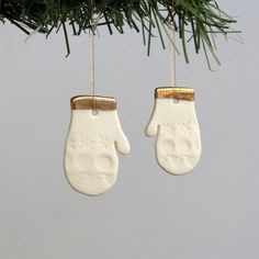 two white mittens hanging from a christmas tree