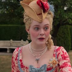 a woman in a red and white dress with a hat on top of her head