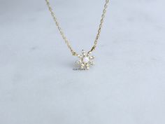 "Add a touch of whimsical charm to your look with our Mini Opal Rhinestone Daisy Flower Pendant Necklace. This adorable necklace features a delicate daisy flower pendant with a shimmering opal stone at the center and petite rhinestone accents, all suspended from a dainty 18k gold dipped chain. The opal stone symbolizes creativity, inspiration, and emotional healing, making this necklace not only a fashionable accessory but also a meaningful piece. The combination of the opal and rhinestones creates a subtle sparkle that catches the light beautifully. Comfortable fit, and the timeless design makes it suitable for any occasion. Whether you wear it alone or layer it with other necklaces, this Mini Opal Rhinestone Daisy Flower Pendant Necklace is sure to make a statement. -18k Gold Dipped * Br Minimalist Wedding Charm Necklace With Flower Charm, Minimalist Wedding Flower Charm Necklace, Dainty Charm Necklaces For Party, Dainty Flower Charm Necklace For Wedding, Wedding Flower Pendant Charm Necklace With Delicate Chain, Delicate Flower Shaped Necklace For Bridesmaid Gift, Dainty White Charm Necklace For Bridesmaids, Wedding Charm Necklace With Delicate Chain And Flower Shape, Wedding Charm Necklace With Delicate Flower Chain