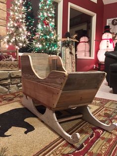 a wooden sleigh sitting on top of a rug next to a christmas tree