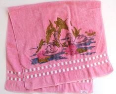 two pink towels with swans on them sitting next to each other