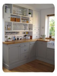 a kitchen with gray cabinets and wooden floors