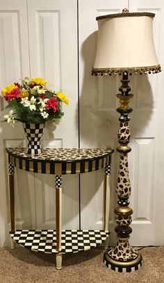 a lamp sitting next to a table with flowers on it