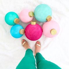 a woman laying on top of a bed next to colorful balls