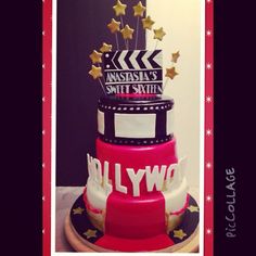 a three tiered cake with hollywood written on top and gold stars around the edges