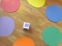 there are many different colored circles on the floor with a small object in front of them