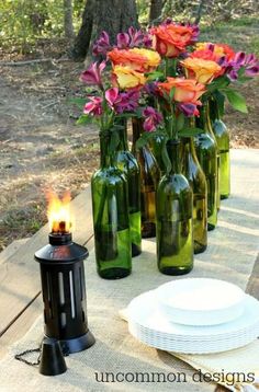 seven simple secrets to backyard entertaining with flowers in green glass bottles on a picnic table