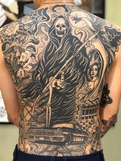 the back of a man's body with tattoos on it and an image of a skeleton