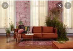 a living room filled with furniture and pink wallpapered walls, along with potted plants