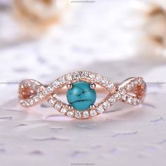 an image of a ring with turquoise stones in the middle and white diamonds around it