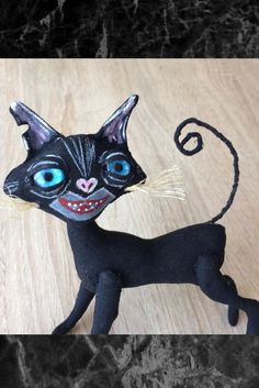 a black cat with blue eyes on a wooden surface