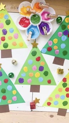 christmas trees made out of construction paper and colored glue on a table with other crafting supplies