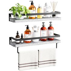 two shelves with towels, soaps and lotion bottles on them in front of a potted plant