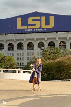 a woman is standing in front of a stadium