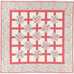 a red and white quilt with flowers on the center is displayed in front of a white background