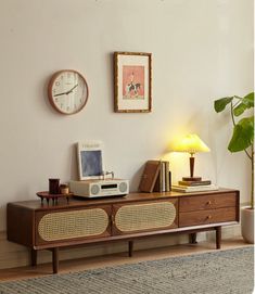 a living room with a clock, radio and other items on the sideboard in front of it