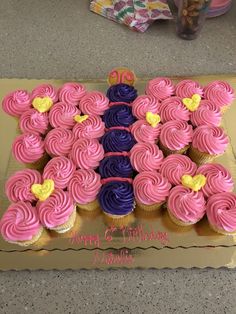 a birthday cake with pink and purple cupcakes in the shape of a butterfly