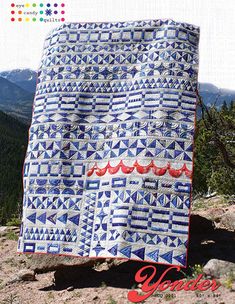 a blue and white quilt sitting on top of a mountain