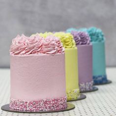 there are four different colored cakes on the table