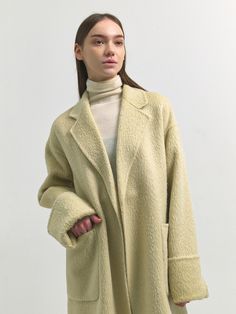 Editor's Notes Woven from suri alpaca blend wool fabric, this relaxed fit coat has minimalistic, luxurious silhouette. It is accentuated with voluminous, hairy texture and rolled-style cuffs. - Soft and cozy alpaca blend coat- Intended for a loose fit- Comfortable dropped shoulders- Detachable waist strap detail- Wide out pockets- Back slit detail for added flexibilityMeasurements(in.)Size One Size(XS-M)- Length: 43.90 in - Shoulder: 21.46 in - Bust: 21.54 in - Hem: 24.41 in - Sleeve length: 27.36 in - Sleeve width: 8.66 in - Sleeve hem: 7.48 in * Model info: Height 5' 7 Bust 33 Waist 25 Hip 34.5 / Height 5' 6 Bust 32 Waist 24 Hip 35 Composition & Care- 51% Wool, 38% Suri Alpaca, 6% Alpaca, 5% Nylon / Lining: 100% Polyester - Dry C Suri Alpaca, Fitted Coat, Waist Strap, Wool Fabric, Light Yellow, Alpaca, Hand Made, Loose Fitting, Jackets & Coats