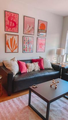 a living room with couches, tables and pictures on the wall above them is shown