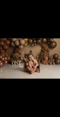 a baby sitting on a chair in front of a wall with balloons and teddy bears