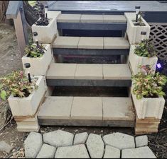 a set of steps with planters on each side and some flowers in the middle