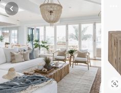 a living room filled with furniture and a chandelier hanging over the top of it