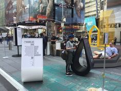 people are standing around in the middle of a city street with large sculptures on display