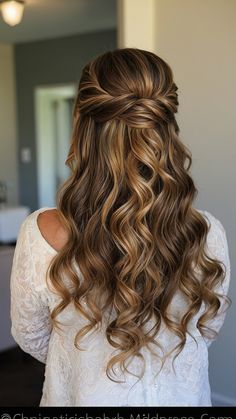 the back of a woman's head with long, curly hair in half - up style