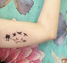 a woman's arm with birds and flowers on it