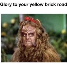 a troll with long hair and red bow on it's head, text reads glory to your yellow brick road