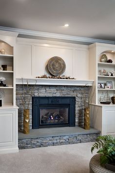 a living room filled with furniture and a fire place in front of a stone fireplace