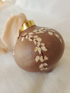 a brown vase with white flowers painted on it