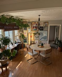 a living room filled with furniture and lots of plants on top of wooden flooring