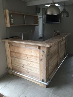 a wooden bar sitting in the middle of a room next to a wall mounted tv