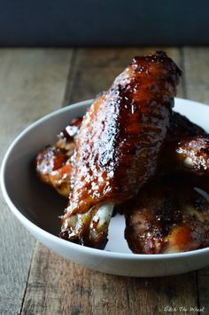 two pieces of meat in a bowl on a wooden table