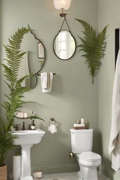 a white toilet sitting next to a sink in a bathroom under a mirror with two mirrors above it