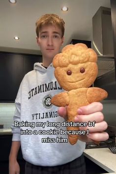 a young man holding up a cookie teddy bear in his hand with the caption saying, baking my long distance boyfriend into a cookie because i miss him