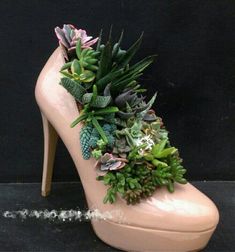 a pair of pink high heeled shoes with succulents on the side