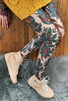 a woman with tattoos on her legs and leggings