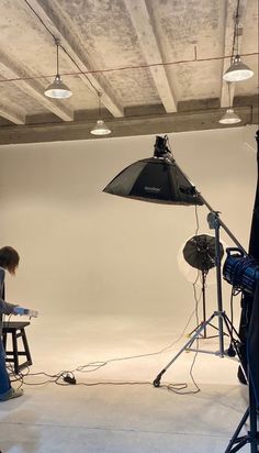 a woman sitting at a table in front of a camera set up for a photo shoot