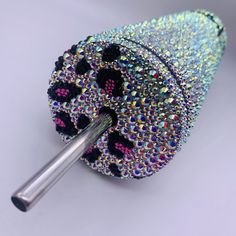 a blue case with multicolored sequins and a brush in the middle