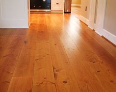 an empty living room with hard wood flooring and white trim on the door way