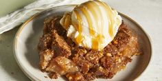 a white plate topped with a piece of pie covered in ice cream and caramel