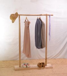 clothes and shoes are hanging on a wooden rack