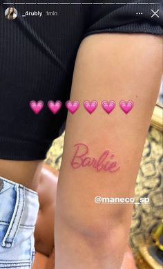 a woman's arm with pink hearts and the word barbie written on it in cursive writing