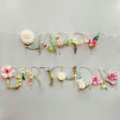 flowers are hanging on a string that says happy birthday