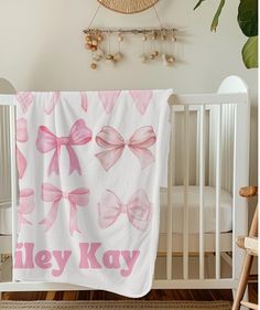 a baby crib with a pink and white blanket that says hey kay