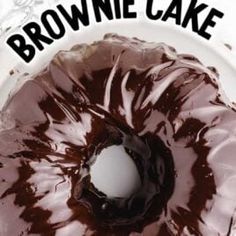 a chocolate frosted donut sitting on top of a white plate with the words brownie cake